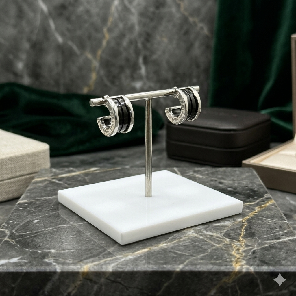 Pair of hoop earrings on a white stand against a marble background