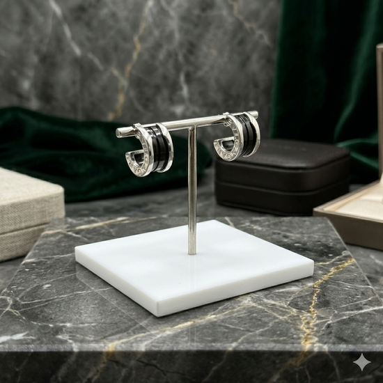 Pair of hoop earrings on a white stand against a marble background
